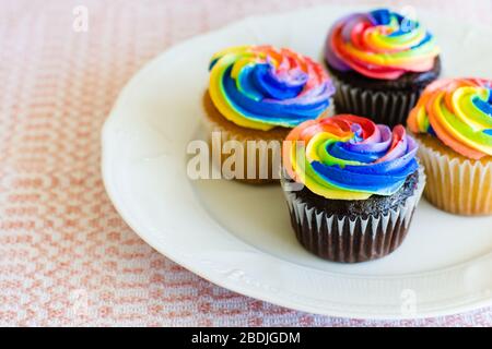 Schokolade und Vanille Cupcakes mit Regenbogen creaming Stockfoto