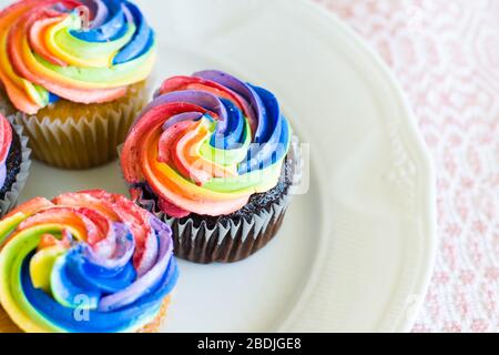 Schokolade und Vanille Cupcakes mit Regenbogen creaming Stockfoto