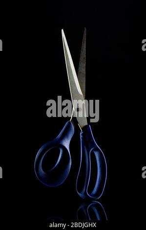 Schere mit Studiobeleuchtung auf dunklem Hintergrund Stockfoto