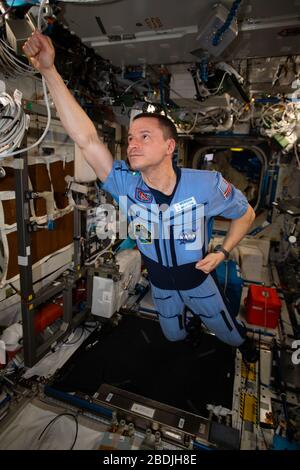 ISS - 29. März 2020 - NASA-Astronaut und Expedition 62 Flugingenieur Andrew Morgan schlägt eine Superheldenpose im schwerelosen Umfeld der Int Stockfoto