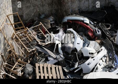 Müllhalde alter Autoteile in der Stadt. Ein Berg von Altmetall aus Autos, Holzpaletten und Bretter. Berg des Mülls. Stockfoto