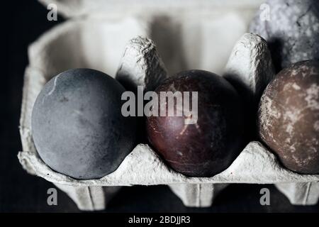 Ostereier in Eizerkasten, natürlich mit rotem Traubensaft gefärbt. Selektiver Fokus. Stockfoto