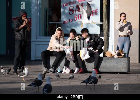 Die Menschen entmutigen die Regeln der sozialen Distanzierung in einem ruhigen Stadtzentrum von Cardiff während der Sperrung des Coronavirus (COVID-19). Stockfoto