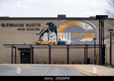Carol Stream, Illinois, USA. Ein verlasser Parkplatz und ein Eingangsbereich einer Highschool unterstreichen die Reaktion auf die Coronavirus-Pandemie in den USA. Stockfoto