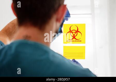Symbol für Biohazard: Warnhinweis zu biologischen Bedrohungen, schwarzer gelber Text für Dreiecksschilder Stockfoto