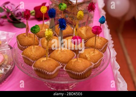 Essen, Backen und Urlaub Konzept - kleine Kuchen oder Muffins mit halloween party Dekorationen und Bonbons an der Platte. Stockfoto