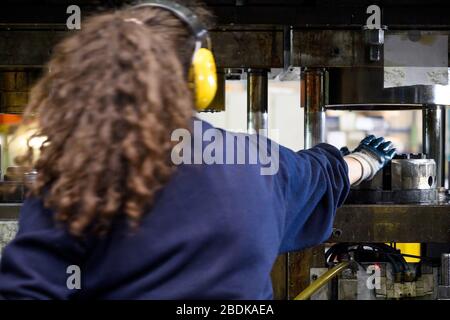 Unerkennbare Frau, die in einer Fabrik arbeitet. Stockfoto