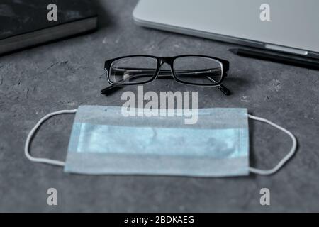 Arbeiten Sie von zu Hause aus. Tastatur, Telefon, medizinische Schutzmaske, antiseptisch auf dem Tisch. Das Konzept der Remotearbeit während des Quarantäne-Coronavirus, Kopierraum. Stockfoto