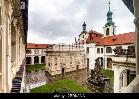 Das Loreto (Loreta) Heiligtum, Prag. Kirche der Muttergottes von Loreto, Innenhof mit dem Heiligen Haus und dem Uhrturm dahinter. Stockfoto