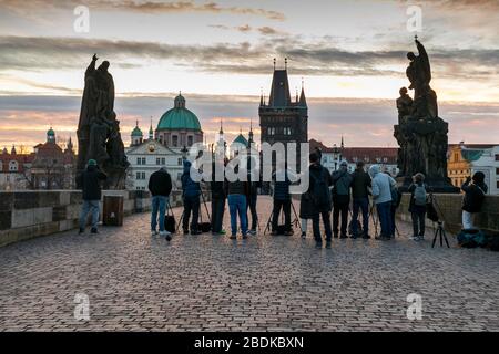 Eine Gruppe von Fotografen bereit, um den Sonnenaufgang auf der Karlsbrücke mit den Türmen und Türmen der Altstadt jenseits, Prag, Tschechische Republik zu erfassen Stockfoto