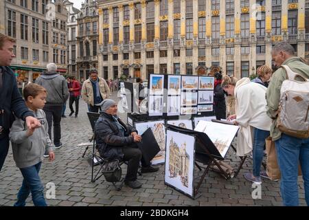 Brüssel, Belgien - 12. Oktober 2019: Ein lokaler Maler, der seine Arbeit am Grand-Place in Mittel-Brüssel zeigt. Der Grand Place ist ein beliebter Touristenort