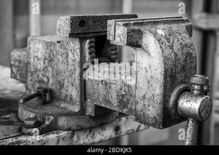 Alter rostiger Schraubstock zum Arbeiten, Sichern durch Anziehen und Bearbeiten von Metall und Teilen Stockfoto