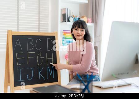 Asian Woman Teaching English Alphabet via Videokonferenz E-Learning an Grundschüler, Homeschooling und Fernunterricht, onlin Stockfoto