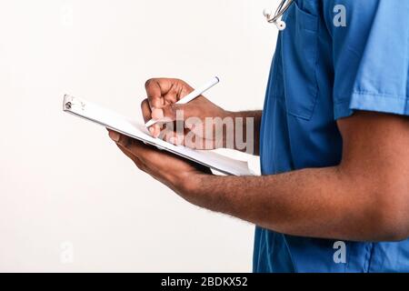 afroamerikanischer Arzt schreibt in medizinischen Diagrammen Stockfoto