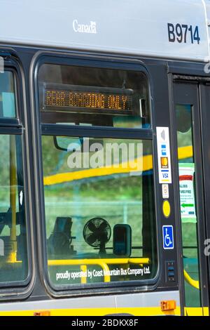 N. Vancouver, Kanada - 7. April 2020: Öffentlicher Transitbus mit Meldung für Passagiere, die während der Pandemie von Coronavirus Hintertüren des Fahrzeugs betreten Stockfoto