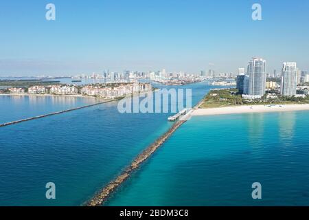 Government Cut, South Beach und Fisher Island am sonnigen Morgen mit City of Miami Skyline im Hintergrund. Stockfoto