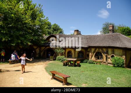 WAIKATO, NEUSEELAND - 4. April 2020: Mädchen hält Bären im Green Dragon Inn, Hobbiton Filmset Stockfoto