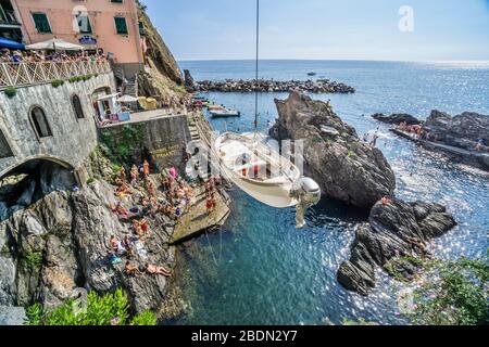 In der Cinque Terre, der ligurischen Riviera di Levante, Ligurien, Italien, ist ein Boot in den von Felsen gesäumten Hafen von Manarola eingesenkt Stockfoto