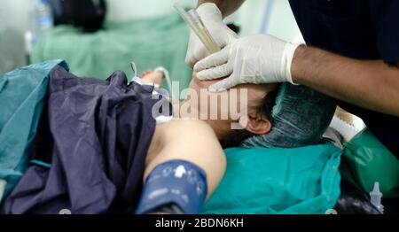 Der Arzt des Anästhesisten wendet den Endotrachealtubus auf den Patienten an. Geringe Schärfentiefe Stockfoto