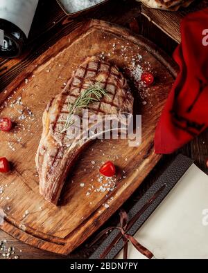 Gebratenes Steak Stück mit Gewürzen auf einem Holzbrett verarbeitet Stockfoto