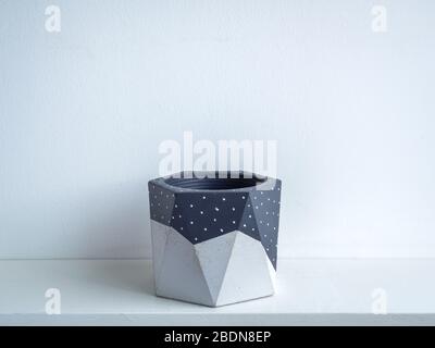 Kaktustopf. Betontopf. Leere grau lackiert moderne geometrische Beton Pflanzmaschine auf weißem Holzregal isoliert auf weißem Hintergrund. Stockfoto