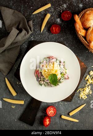 Gemüsesalat mit Tomaten und Gurken, gewürzt mit Mayonnaise Stockfoto