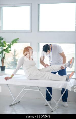 Schön gealterte Patientin, die auf dem Krankenbett sitzt Stockfoto