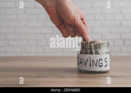 Hand setzen oder Geld aus Glas auf weißem Hintergrund nehmen Stockfoto