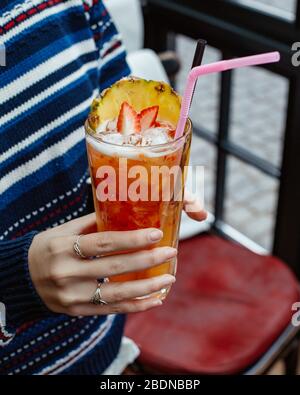 Frau hält ein Glas Ananas und Erdbeer-Cocktail Stockfoto