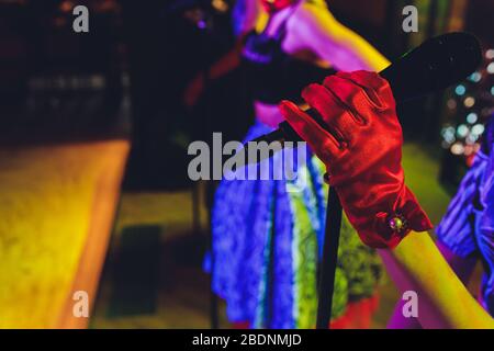 Weibliche Hand, die ein einziges Retro-Mikrofon vor bunten Hintergrund Stockfoto