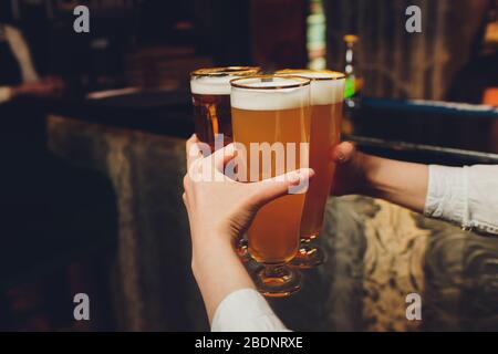 Der Kellner hält in einer Bar oder Kneipe eine Brille Bier in den Händen. Biergläser Stockfoto