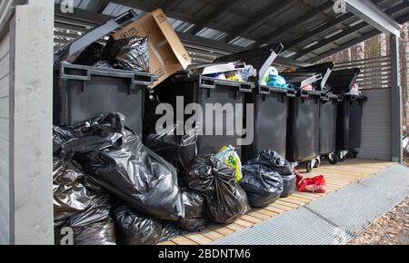 Überfüllte 400-Liter-Haushaltsmüllbehälter an der Sammelstelle für Gemeinschaftsabfälle in Finnland Stockfoto