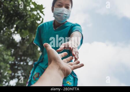 Hände von Menschen in medizinischen Handschuhen, die sich für das Hope COVID-19-Konzept ausstreten. Stockfoto
