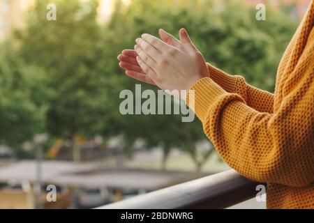 Stock Foto von den Händen einer jungen Frau klatschen vom Balkon, um das medizinische Team zu unterstützen Stockfoto