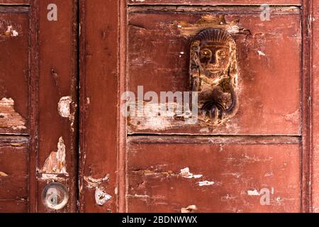 Detail einer alten, verwitterten und rustikalen Tür mit einem rostigen, ägyptischen Thema Türklopfer Stockfoto
