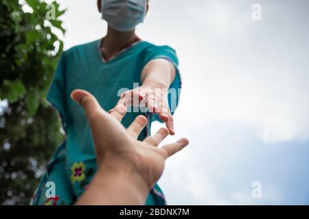 Hände von Menschen in medizinischen Handschuhen, die sich für das Hope COVID-19-Konzept ausstreten. Stockfoto
