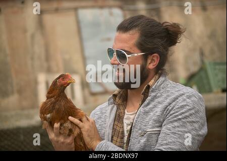 Bauer hält ein Huhn in der Hand Stockfoto