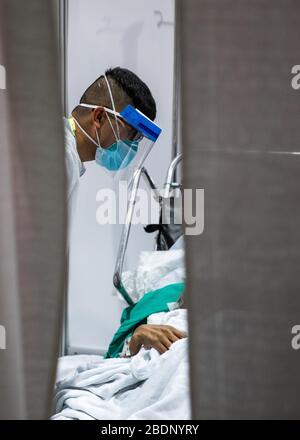 NEW YORK, USA - 07. April 2020 - SPC. Aian Foronda, dem Krankenhaus 531st Hospital Center zugeordnet, kümmert sich um einen COVID-19-Patienten in Javits New York Medical Stat Stockfoto