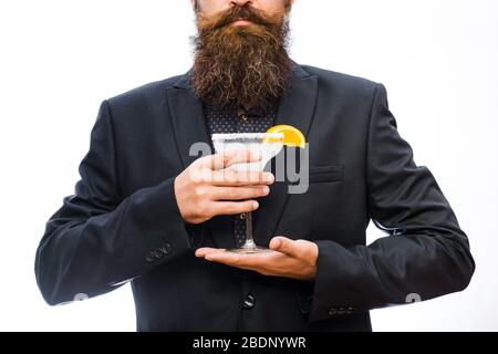 Hiphster bereitete Cocktail vor. Man hält Glas, köstlichen Cocktail mit Orange, margarita. Stilvolles Barkeeper Konzept. Barmann in schwarzer klassischer Jacke mit Bart, gesichtslos, isoliert auf weißem Hintergrund. Stockfoto
