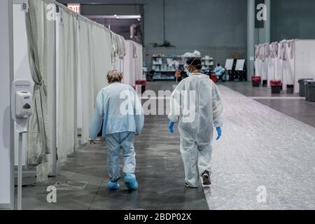 NEW YORK, USA - 07. April 2020 - EIN Soldat, der Javits New York Medical Station (JNYMS) zugewiesen ist, spaziert mit einem Patienten, der sich von COVID-19 in erholt Stockfoto