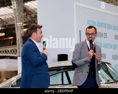 Paul Spires von Aston Works spricht auf der Car Stories Stage 2020 auf der London Classic Car Show über die speziellen Goldfinger Aston Martin DB5 Continuation Cars mit Max Girardo Stockfoto