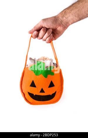 Hand in Halloween Kürbisbeutel mit Süßigkeiten im Inneren isoliert auf weißem Hintergrund Stockfoto