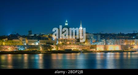 Maltas Hauptstadt Valletta, nachts, über den Hafen in Sliema, mit Kirchen und Gebäuden beleuchtet Stockfoto