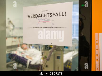 München, Deutschland. April 2020. Während seines Aufenthaltes im Krankenhaus Großhadern liegt ein Patient auf einem Beatmungsgerät und einer Dialysemaschine in einem Intensivpflegeraum. Ein Schild an der Schiebetür "Covid-19-Verdachtsfall - negativ - vollständiger Austausch der Schutzausrüstung vor dem Betreten" deutet darauf hin, dass ein Covid-19-Verdacht im Mann nicht bestätigt wurde. Kredit: Peter Kneffel / dpa / Alamy Live News Stockfoto