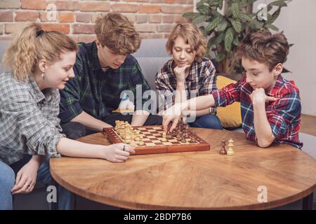 Konzept der Freundschaft, Kommunikation und Menschen - eine Gruppe von jungen glücklichen Freunden zu Hause ausruhen, spielen, reden, Fernsehen Stockfoto