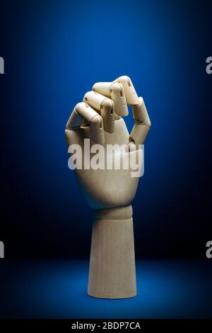 Künstliche Intelligenz Holzhandansicht mit geschlossenen Fingern auf einem klassischen blauen Hintergrund Stockfoto