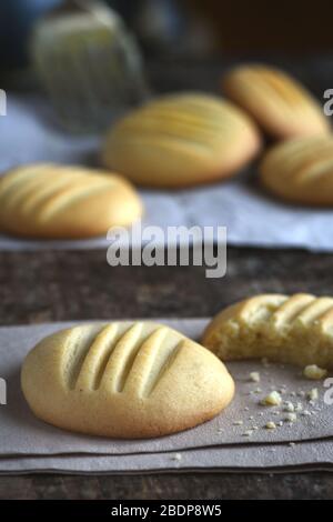 Vertikales Bild von frisch gebackenen Butterkeksen mit gebrochenem Keks, aufgenommen im selektiven Fokus für verblassten Hintergrund für Rezepttext oder Kopierbereich Stockfoto