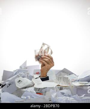 Konzept Geschäftsbild eines Arms, der aus einem Stapel von Einnahmen und Papierkram kommt, der Geld vor einem weißen Hintergrund erfasst. Stockfoto