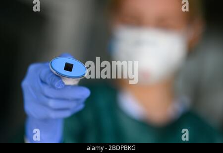 09. April 2020, Baden-Württemberg, Stuttgart: Eine Ärztin hält vor dem Eingang zum Katharinenhospital des Klinikums Stuttgart ein klinisches Thermometer in der Hand. Der Arzt misst die Temperatur aller Besucher, die das Gebäude betreten, und fragt nach Husten und möglichen Kontakten mit Menschen, die positiv auf das Corona-Virus getestet haben. Foto: Sebastian Gollnow / dpa Stockfoto