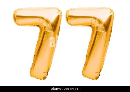Nummer 77 siebzig sieben aus goldenen aufblasbaren Ballons isoliert auf Weiß. Heliumballons, Goldfolienummern. Partydekoration, Jubiläumsschild Stockfoto